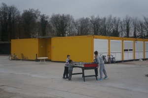 Children play foosball outside the containers that house asylum-seekers in a refugee camp at Linkenheim, Germany. Photo by Kavitha Surana